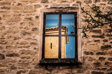 Reflejo de castillo en ventana. Pequeño pueblo medieval de España