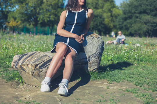 Young woman relaxing on log in park