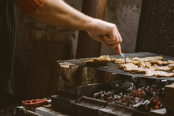 Man grilling pork meat chops on barbecue