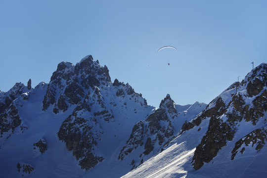 Para-gliders above ski mountainsin the Three Valleys, France.