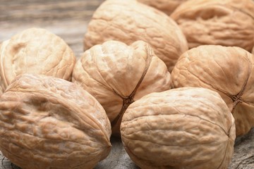 Walnut kernels and whole walnuts on rustic old wooden table