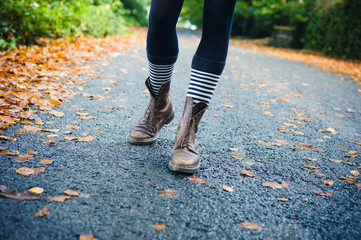 Legs of young woman walking in autumn