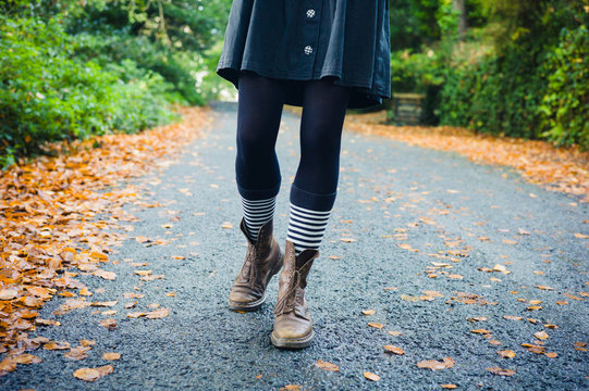 Legs of young woman walking in autumn