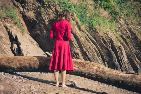 Woman in red standing on the beach