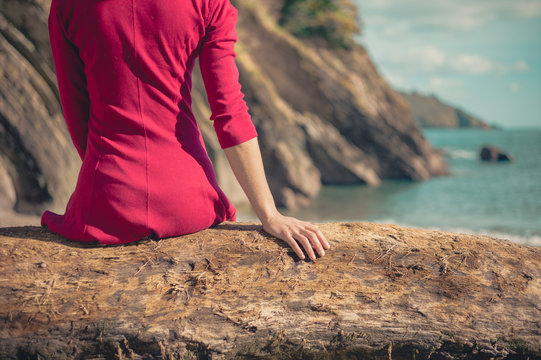 Young woman in red dress relaxing on beach