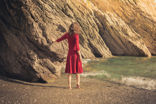 Woman in red dress walking on the beach