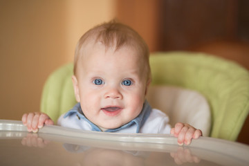 babyboy eating in high chair