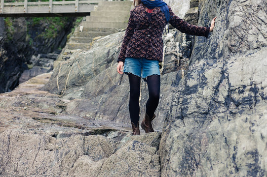Young woman standing by rocks on coast