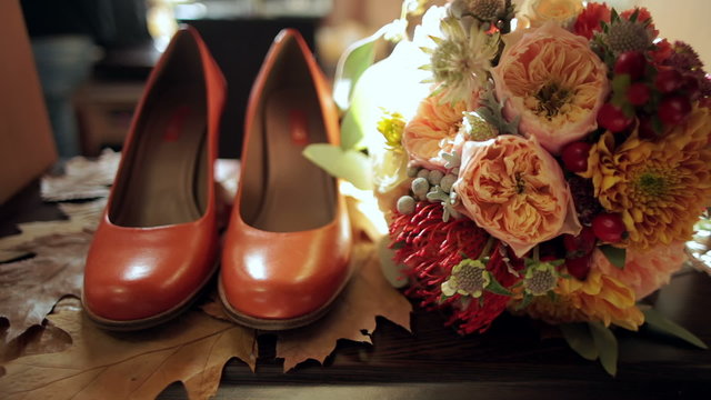bridal bouquet and bride's shoes on autumn leaves 