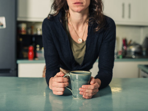 Young woman drinking coffee in kitchen