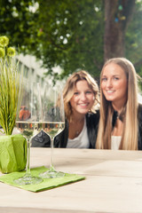 Zwei Freundinnen mit Sektgläsern auf dem Tisch