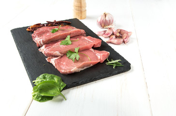 Raw beef steak with peppers and herbs