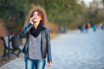 Laughing woman talking on the phone outdoors