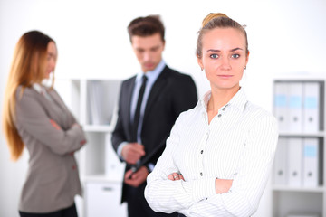 Obraz premium Pretty businesswoman in office with colleagues in the background