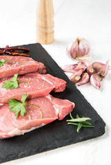 Raw beef steak with peppers and herbs