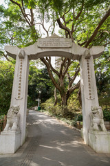 Entrance gate with statues to the Zoological and Botanical Gardens in Hong Kong, China, viewed from the front.