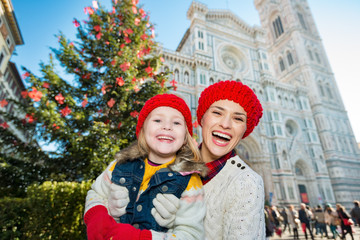 Portrait of mother and daughter near Christmas tree in Florence
