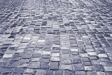 Road with wet cobblestones in rainy weather