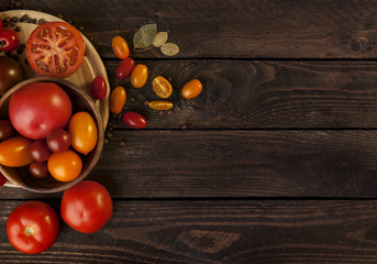 Fototapeta na wymiar Fresh cherry tomatoes on rustic dark wooden background