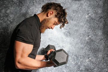 Muscular man with the beard training in the gym