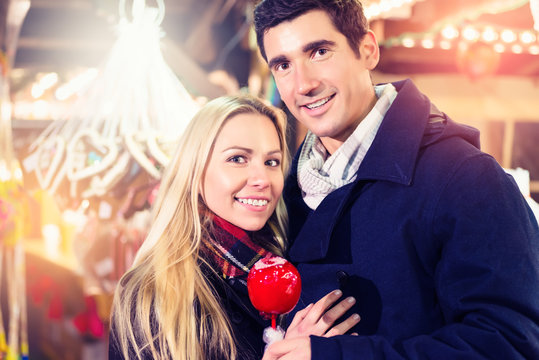 Paar mit Kandisapfel auf Weihnachtsmarkts