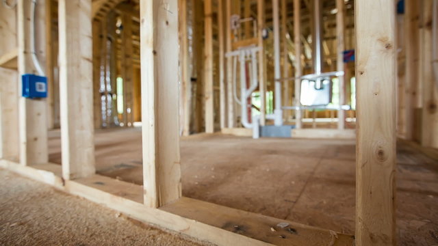 New Home Construction Room Framing Dolly. camera moves left on a newly framed room in a residential home. focus is on the beams in the foreground
