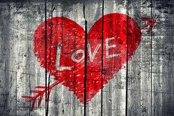 Drawing of a heart with word "Love" on grunge wooden wall backgr