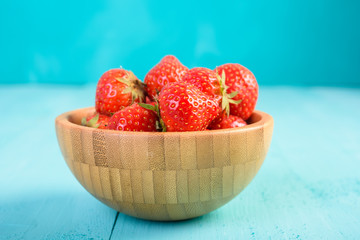 Strawberry Wood Bowl On Blue Boards Background