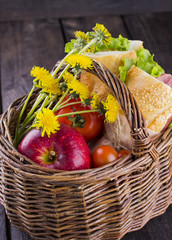 Wattled basket for picnic with sandwiches, apple, tomatoes