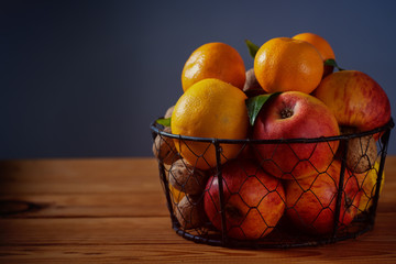 Stillleben  mit Apfelsinen, Mandarinen und Apfel im Korb