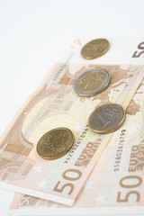Fünfzig Euro Scheine gefächert mit diversen Euromünzen