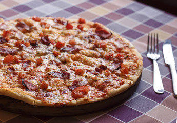 Pizza with bacon and tomatoes