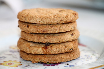 Fototapeta na wymiar Fresh oatmeal cookies with seeds of cereals and raisins 