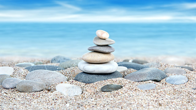 Tower of stones on sea beach background
