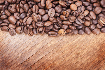 coffee grains on grunge wooden background closeup