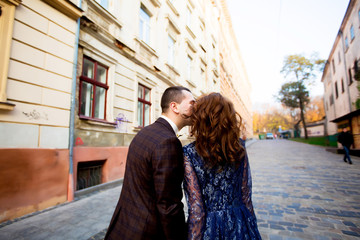 Fototapeta premium Lovely wedding couple kissing in the city