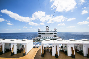 Tourists relax and take a sun bath on the upper deck of a cruise