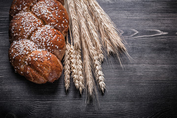 Bread wheat and rye ears on wooden board
