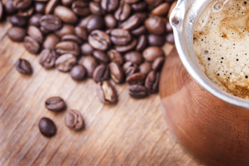 Coffee beans, vintage copper coffee pot closeup, cezve or ibrik