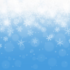 Abstract blue winter background with blurred various snowflakes.