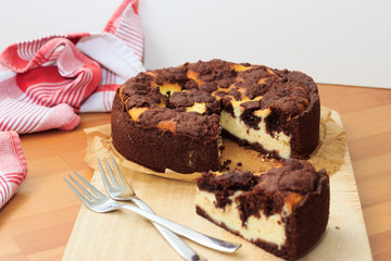 Cheesecake with chocolate shortcrust pastry and chocolate crumble arranged on a wooden board
