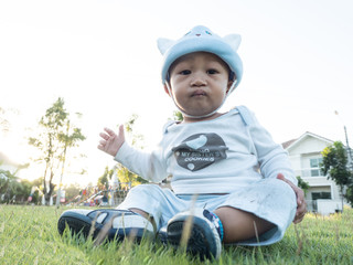 baby sitting on the grass green garden