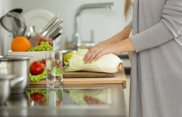 Closeup of woman cutting fresh cabbage for soup
