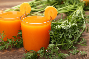 Glasses of carrot juice with vegetables on table close up