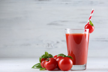 Glass of tomato juice with vegetables on wooden background