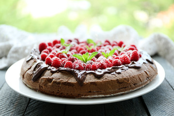 Cake with Chocolate Glaze and raspberries on wooden background