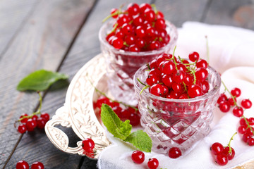 Fresh red currants in glasses on table close up