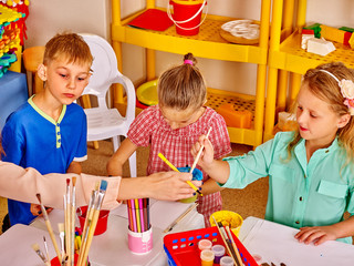 Group little girl with brush painting in  kindergarten .