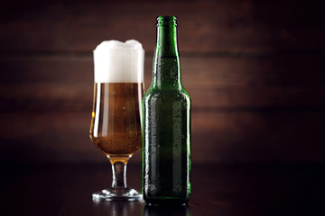 Glass and bottle with beer on the table