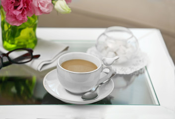 Fototapeta na wymiar Cup of coffee on table in living room